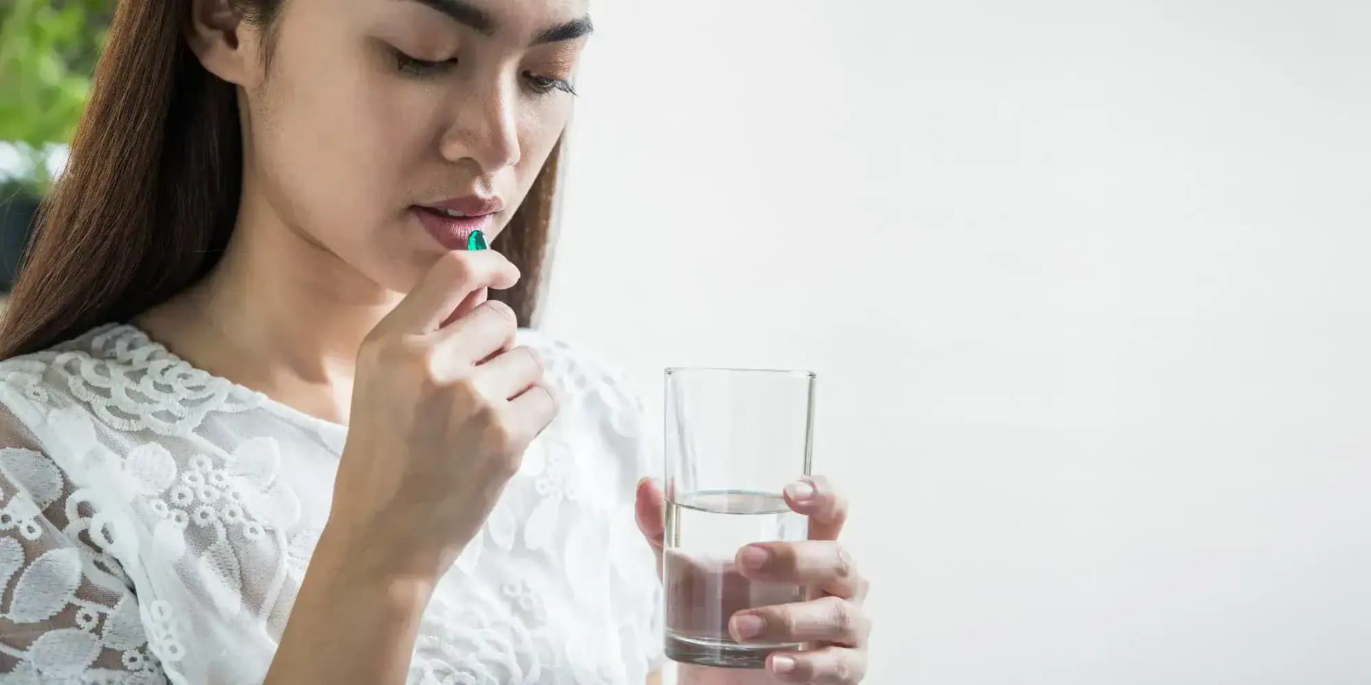 žena si berie vitamíny na akné